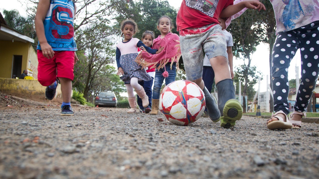 Criança jogar futebol junto com o amigo