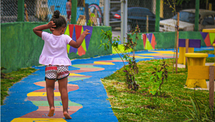 Menina brinca em uma amarelinha pintada na calçada