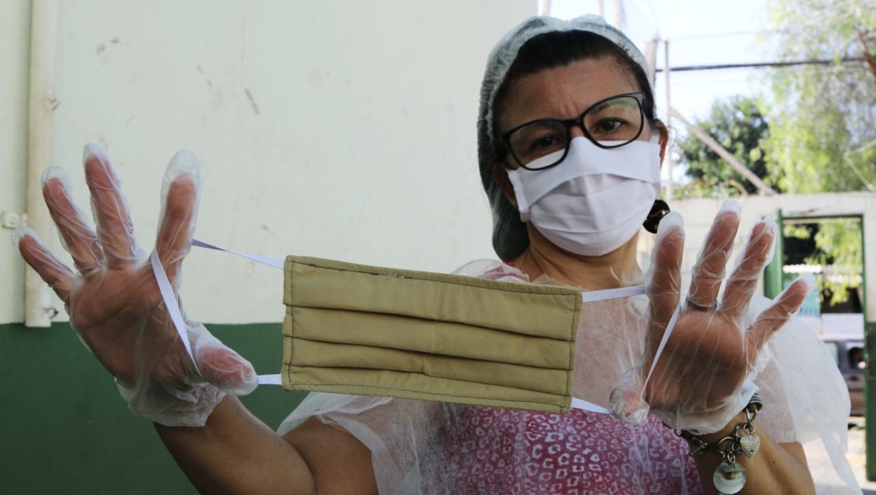 Mulher exibe uma máscara, em um dos projetos apoiados pela FEAC que buscam evitar os efeitos da pandemia junto às organizações da sociedade civil