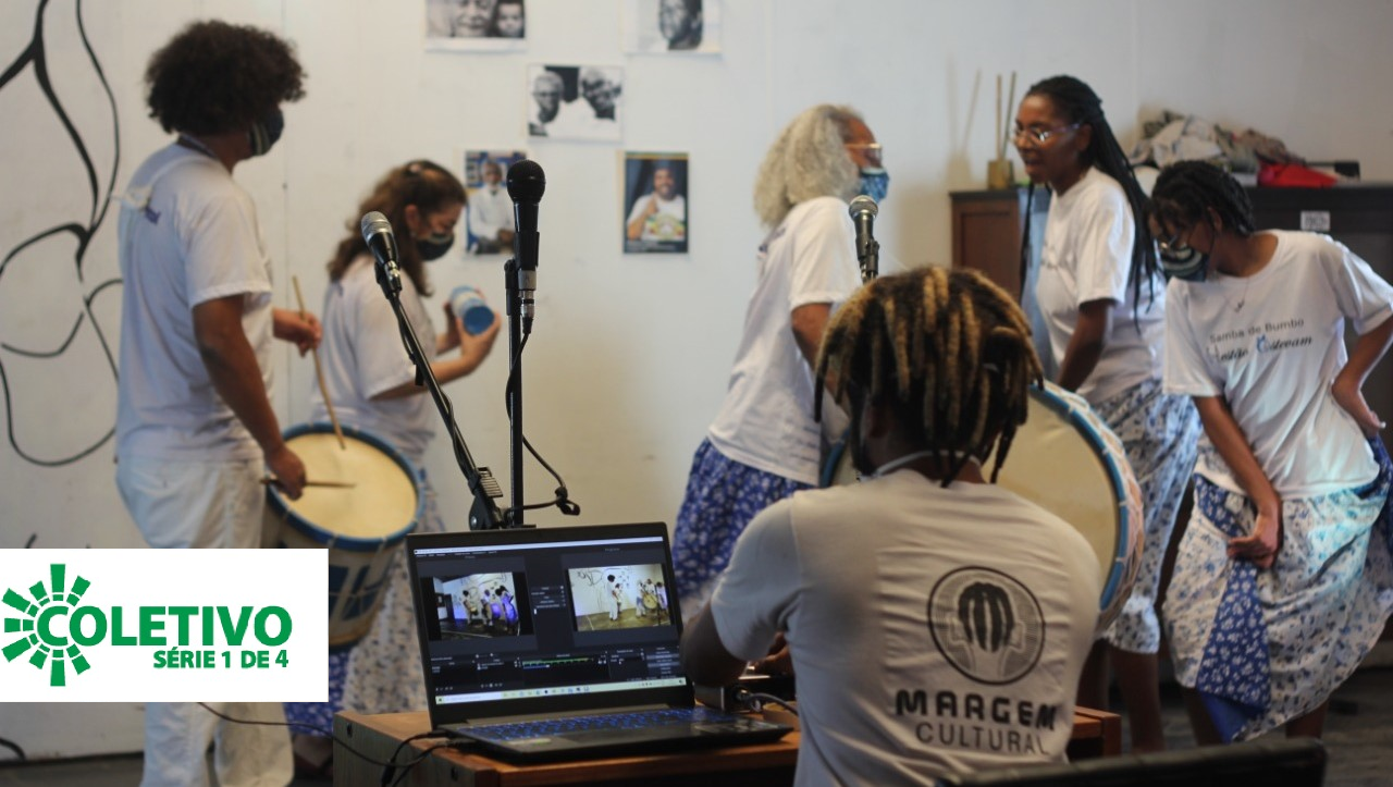 Imagem mostra integrantes do coletivo Margem Cultural em um ambiente interno com microfone e instrumentos musicais.