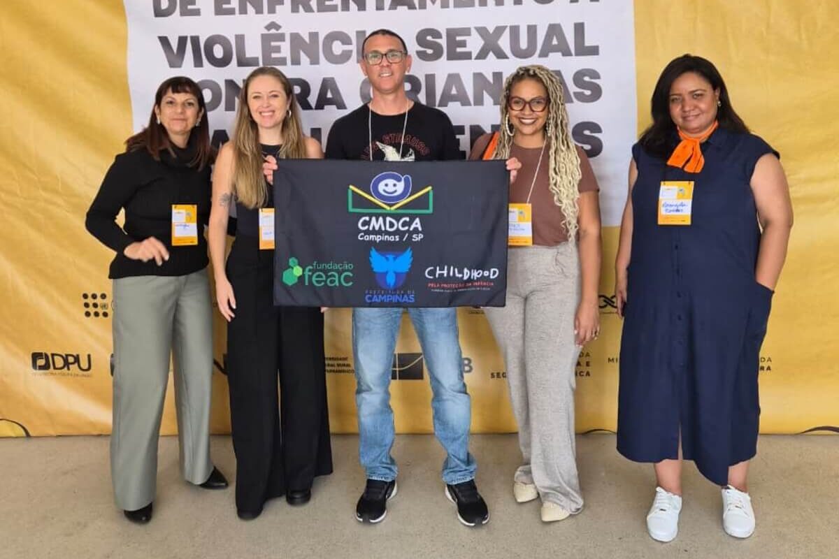 Representantes segurando bandeira durante o III Congresso Brasileiro de Enfrentamento à Violência Sexual contra Crianças e Adolescentes.