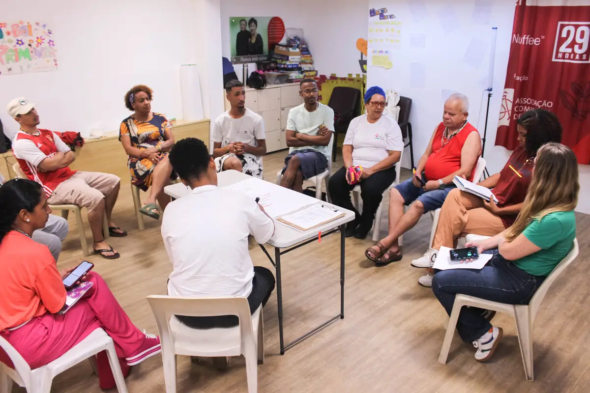 Grupo diverso reunido em roda para diálogo e planejamento em atividade do projeto LabPOP.